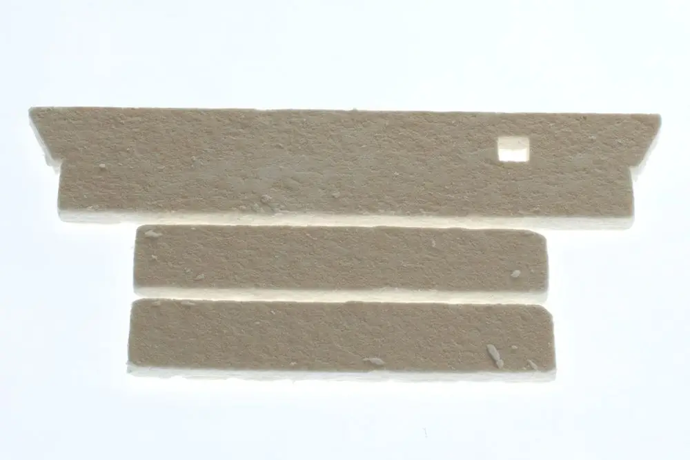 Weißes, rechteckiges Isoliermaterial mit einer Aussparung, das in der Bau- oder Heiztechnik verwendet wird, möglicherweise von Bosch.